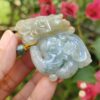 a hand holding a jade elephant