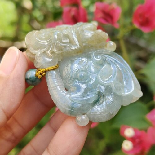 a hand holding a jade elephant