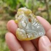 a hand holding a carved stone