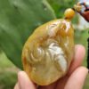 a hand holding a stone pendant