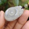 Una mano sosteniendo un colgante de jade.