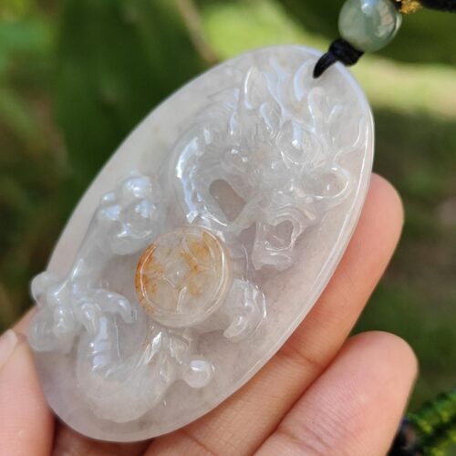 a hand holding a jade pendant