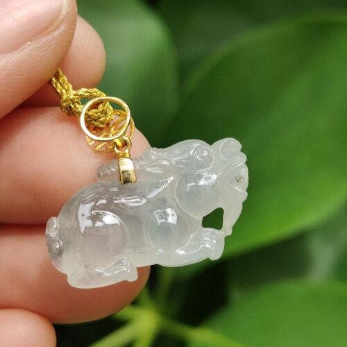 một bàn tay cầm một mặt dây chuyền ngọc bích