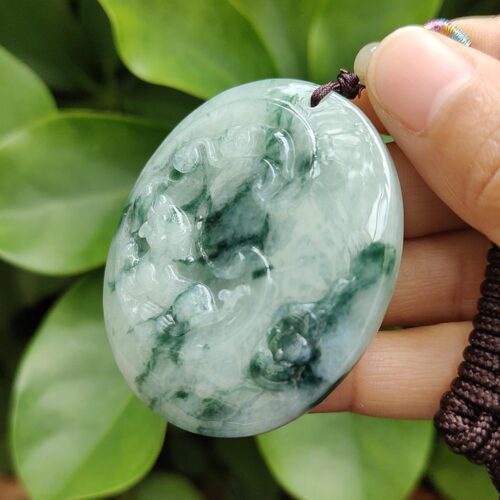 एक हाथ में जेड पेंडेंट थामे हुए