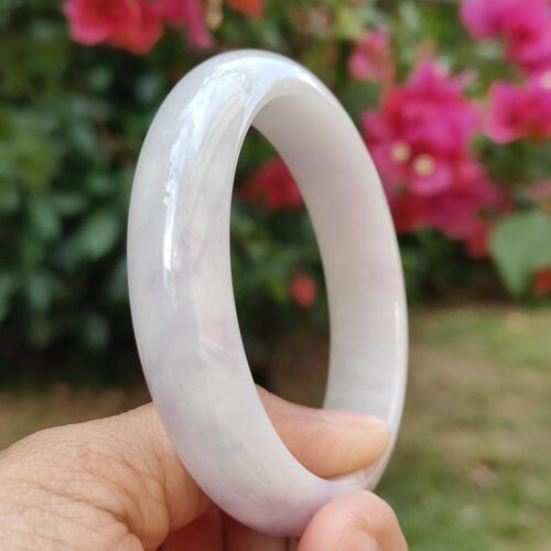 一只手拿着一枚白色的戒指