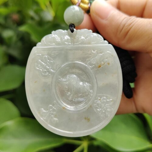 une main tenant un pendentif en jade