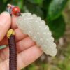 a hand holding a white jade necklace