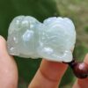 Una mano sosteniendo un colgante de jade.