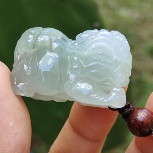 Una mano sosteniendo un colgante de jade.