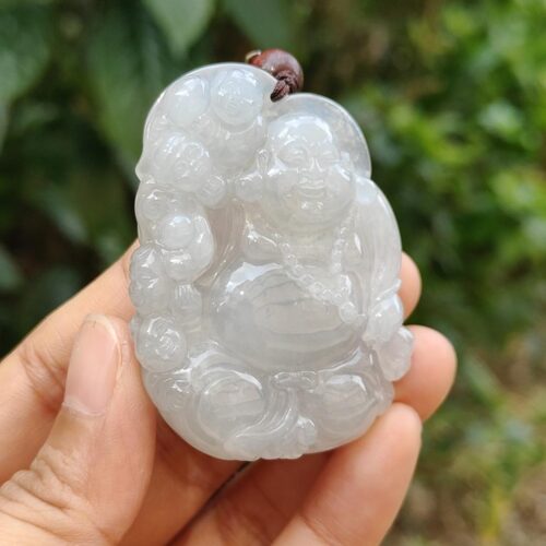 a hand holding a jade pendant