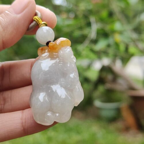 a hand holding a white and yellow bead