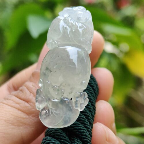 a hand holding a jade animal