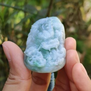 a hand holding a jade object