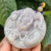 Una mano sosteniendo un colgante de piedra.