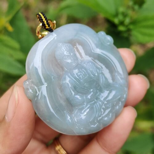 Una mano sosteniendo un colgante de jade.