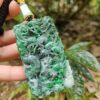 Una mano sosteniendo un colgante de jade.