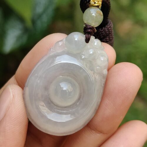 Una mano sosteniendo un colgante de jade.