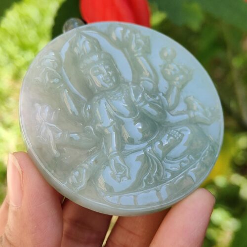 Una mano sosteniendo un medallón de jade.