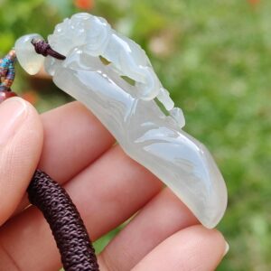 Una mano sosteniendo un colgante de jade.