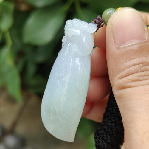 ஜேட் பதக்கத்தை வைத்திருக்கும் ஒரு கை