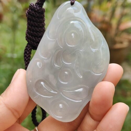 Una mano sosteniendo un colgante de jade.