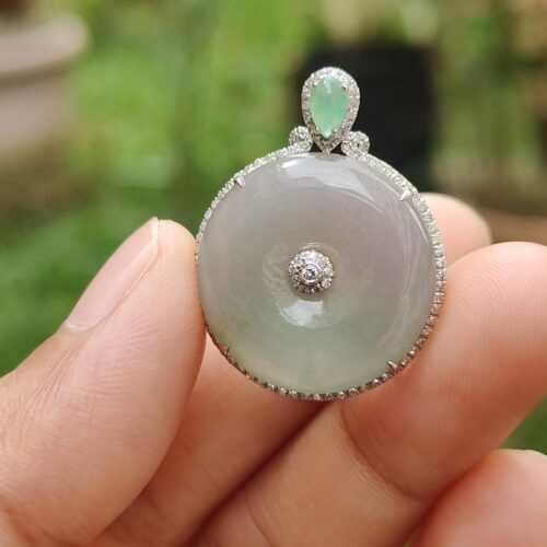 Una mano sosteniendo un colgante de jade.