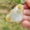 Una mano sosteniendo un colgante de jade.