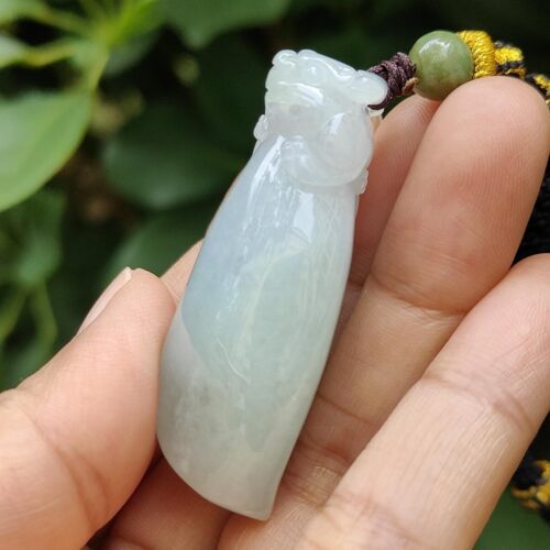 ஜேட் பதக்கத்தை வைத்திருக்கும் ஒரு கை