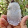 Una mano sosteniendo un colgante de jade.