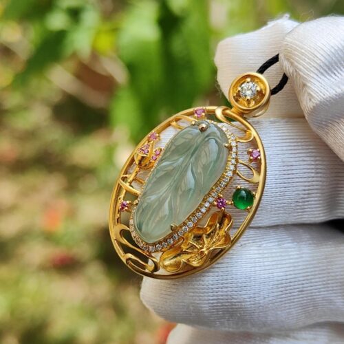 a hand wearing a glove holding a gold pendant