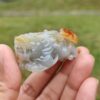 Una mano sosteniendo un pequeño objeto de piedra.