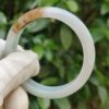 a hand in glove holding a white circular object