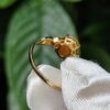 a hand holding a gold ring