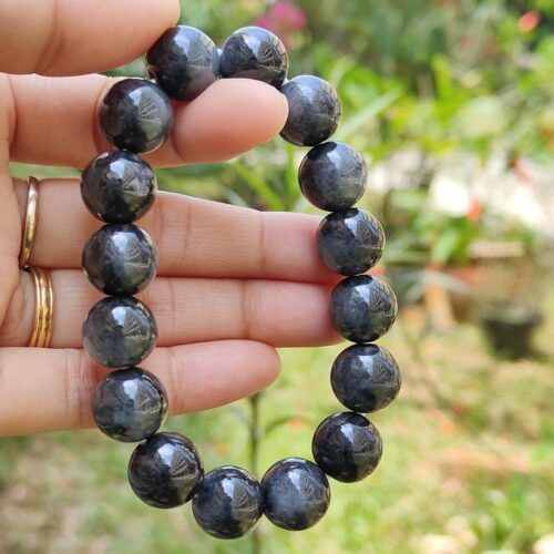 மணிகளால் ஆன வளையலை வைத்திருக்கும் ஒரு கை