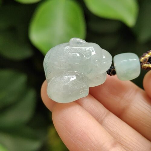 a hand holding a jade bead