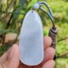 a hand holding a white stone pendant