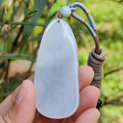 a hand holding a white stone pendant