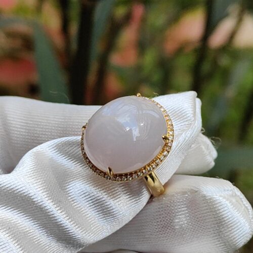 a hand wearing a white glove with a large stone ring
