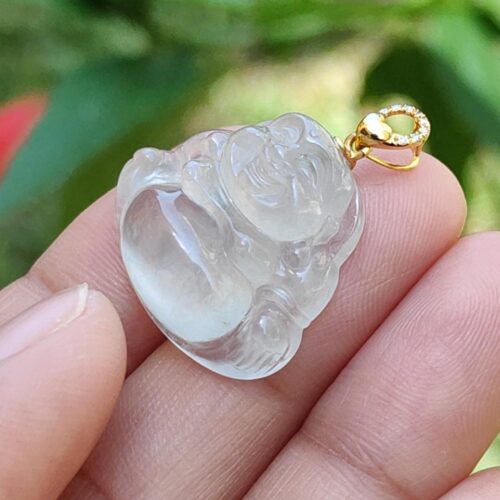 a hand holding a jade pendant