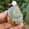 Una mano sosteniendo un colgante de jade.