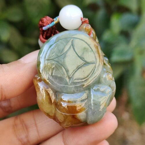 Una mano sosteniendo un colgante de jade.