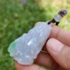 Una mano sosteniendo un colgante de jade.
