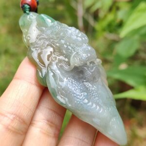 Una mano sosteniendo un colgante de jade.