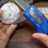 a person holding a small blue device with a digital screen