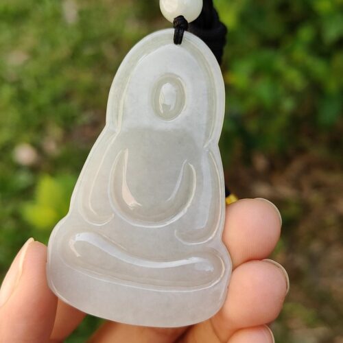 Una mano sosteniendo un colgante de jade.