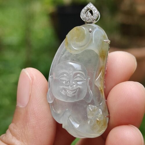 a hand holding a jade pendant