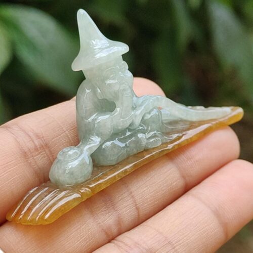 a hand holding a small carved stone statue