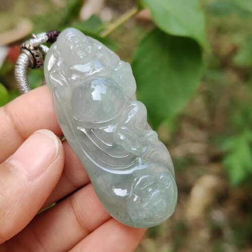 une main tenant un pendentif en jade
