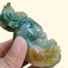 Una mano sosteniendo una estatua de jade