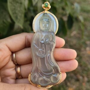 Una mano sosteniendo un colgante de jade.